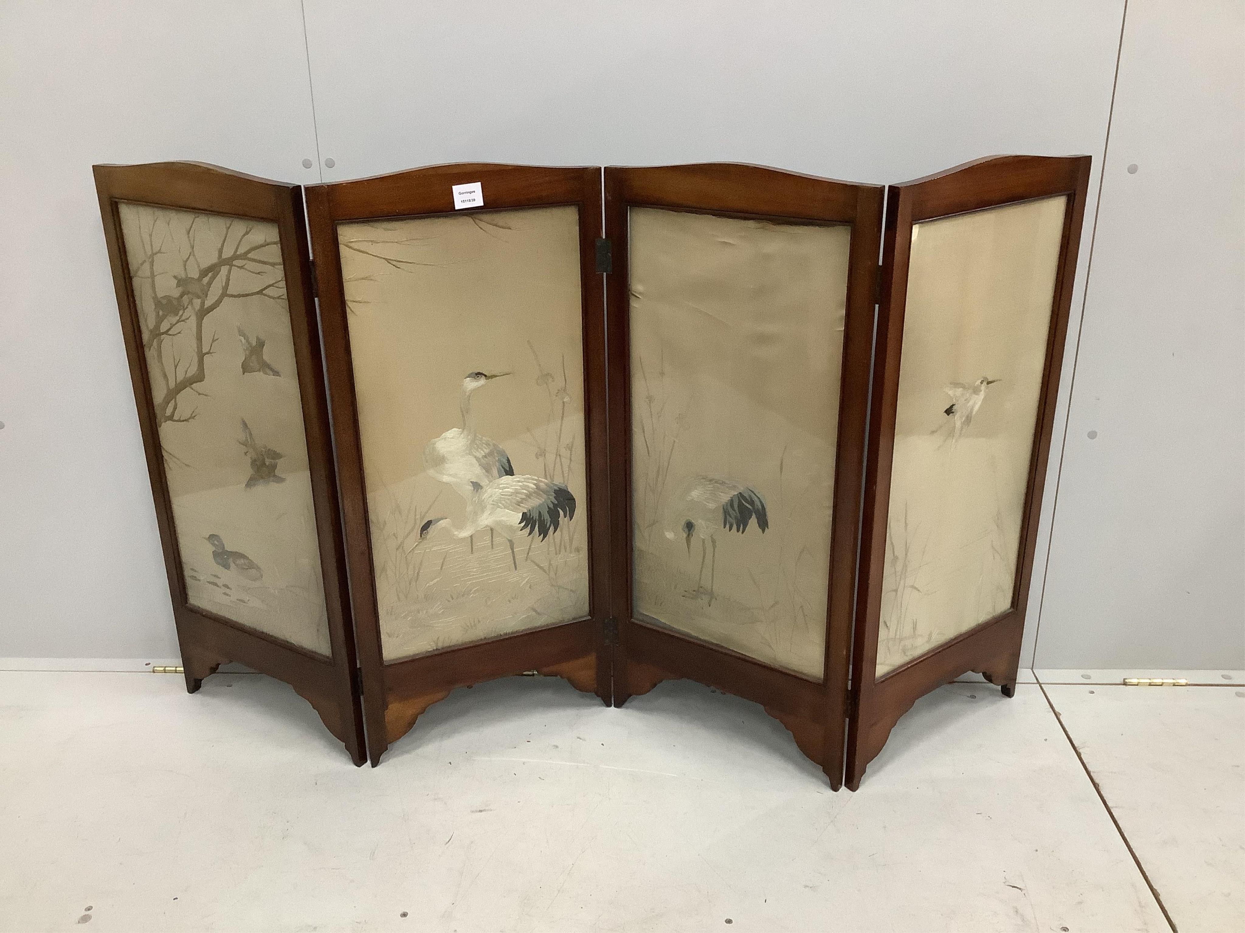 An early 20th century silk thread embroidered four fold table screen, decorated with birds among reeds, each panel width 41cm, height 94cm. Condition - fair